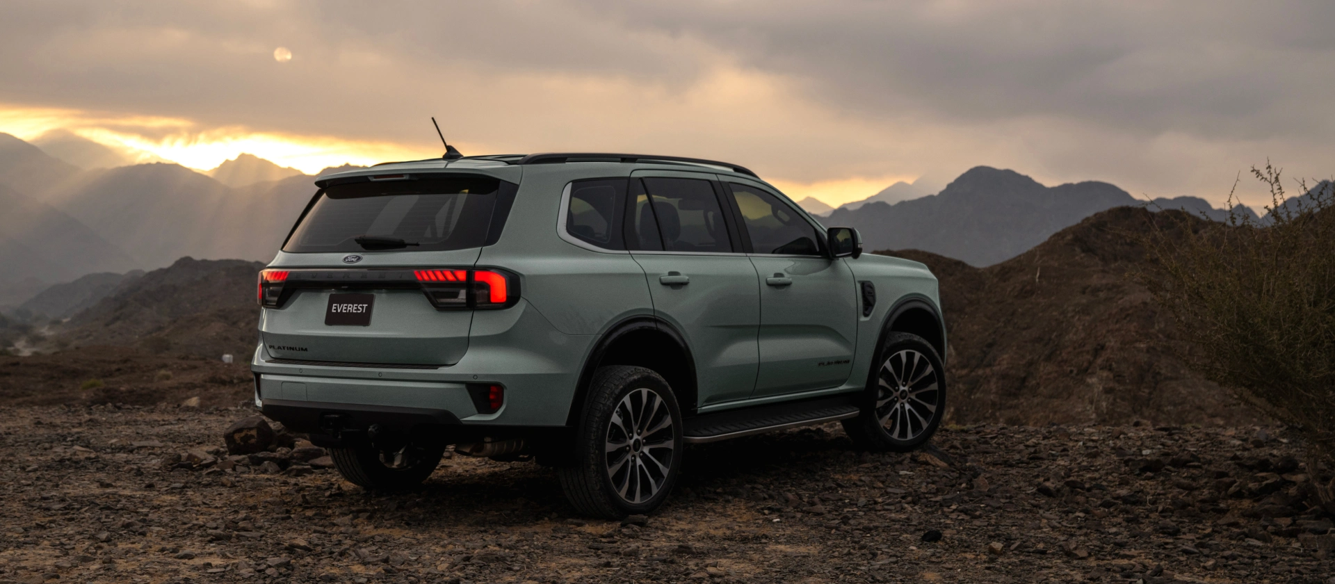 Ford Everest Platinum in Aluminium Metallic on rugged mountain terrain at sunset